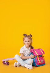 Cute little schoolgirl on color background