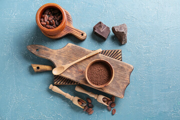 Cacao powder with beans and chocolate on color background