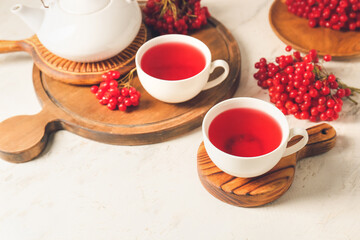 Cups of healthy viburnum tea on table