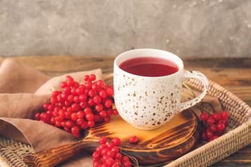 Tray with cup of healthy viburnum tea on table