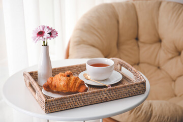 Tray with tasty breakfast on table in room