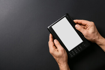 Male hands with e-reader on dark background