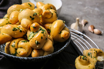 Plate with tasty garlic buns on grey background