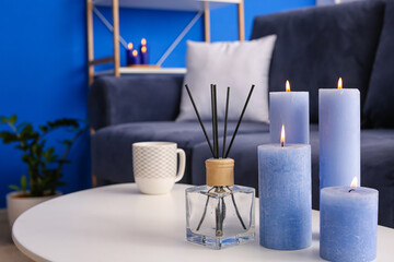 Table with burning candles in interior of room, closeup