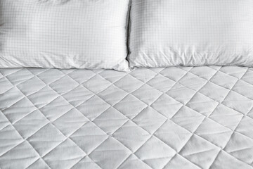 Modern orthopedic mattress with pillows on bed, closeup