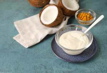 Fototapeta na wymiar Bowl of tasty coconut yogurt on color background