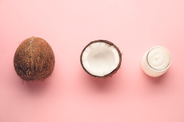 Jar of tasty yogurt and fresh coconut on color background
