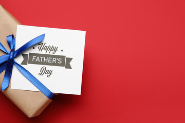 Gift box and greeting card for Father's Day celebration on color background