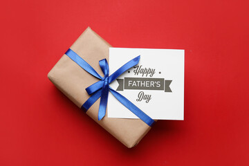 Gift box and greeting card for Father's Day celebration on color background