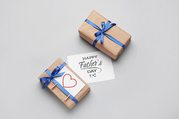 Gift boxes and greeting card for Father's Day celebration on grey background