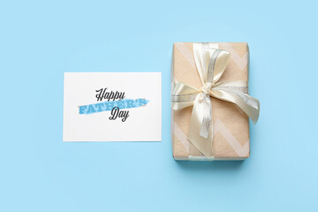 Gift box and greeting card for Father's Day celebration on color background