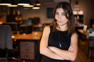Beautiful caucasian woman in a headset is holding a digital tablet. Portrait of a business woman in the office