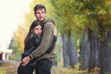 Fototapeta premium Happy Young Couple Walking And Having Fun In Autumn Park. Love Story. Love Spending Time Together. Concept Real People