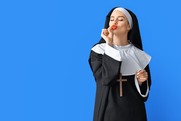 Sexy nun eating chips on color background