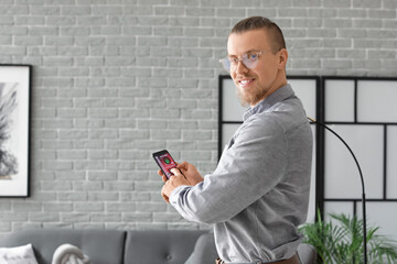 Man with mobile phone using smart home security system application