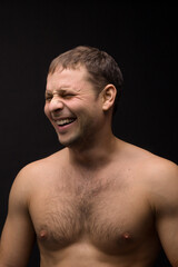 Fototapeta premium Handsome smiling man on the black background. Muscular and athletic. Man portrait. Male model in studio