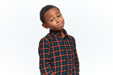 Human emotions, reactions and feelings. Unhappy cute little Afro American boy in plaid shirt...