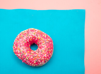 Red donut on a blue and pink background.
