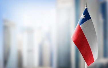 A small flag of Chile on the background of a blurred background