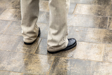 Legs of a man in shoes on the slabs.