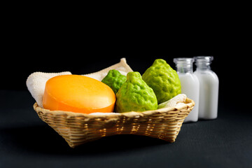 Organic herbal natural product for skin care, Orange soap and fresh bergamot fruit in a basket on black background