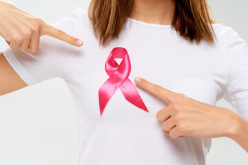 woman in white t-shirt with pink ribbon charity fund against breast cancer