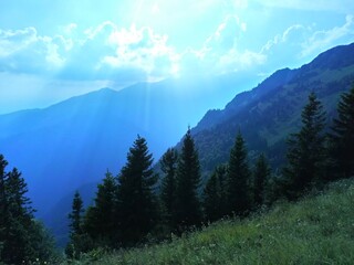 Clouds mountains Alps grass Sun rays