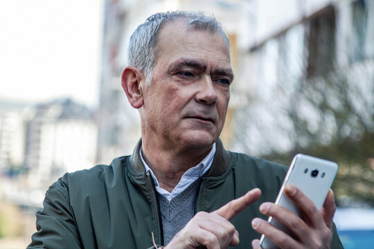 adult man using the phone on the street