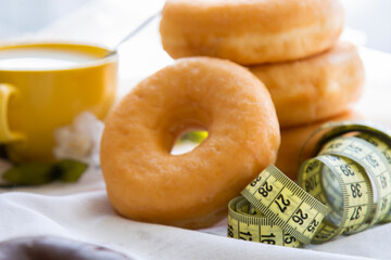 donuts or industrial pastries and measuring tape, diet and food concept
