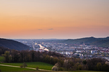 Germany, Orange glowing sunset sky above the houses and neckar river of stuttgart city at dawning from above