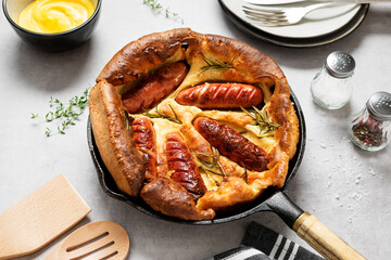 Toad in the hole, Sausage Toad, traditional English dish of sausages in Yorkshire pudding batter.  - 423484600