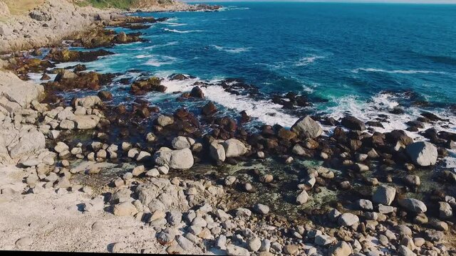 Aerial drone shot over the Chilean coast, cinematic and static stabilized video over the waves hitting the rocks