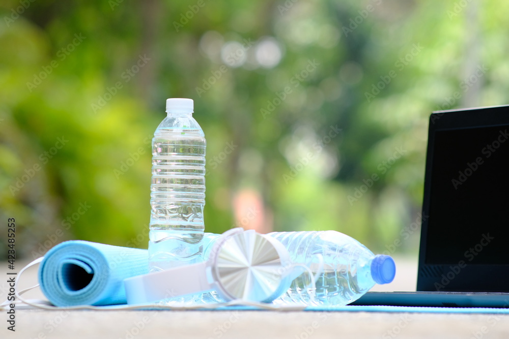 Wall mural Bottle of water in green natural background and space