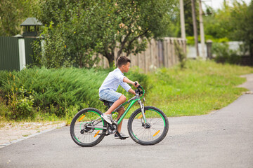 Fototapeta na wymiar Teenage boy is riding on a bicycle