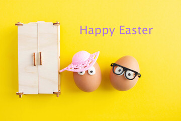 Creative decoration for easter on yellow background, crazy eggs with glasses and hat