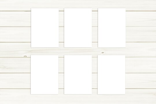 Set of six A5 size cards or posters mockup for design presentation on white wooden background.