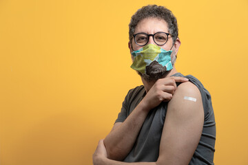 Senior man wearing face mask showing vaccinated arm. coronavirus vaccination concept of man received the corona virus vaccine. - obrazy, fototapety, plakaty
