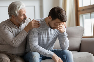 Loving senior Caucasian father hug comfort upset depressed adult grownup son feeling lonely...