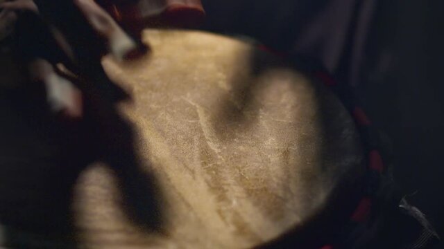 Black man claps palms in an African drum, close up. Musician plays the drum with hands.