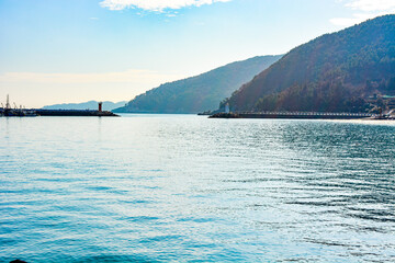 Obraz premium The wide blue ocean seen from the beach with a mountain