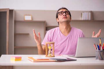 Young male student in time management concept