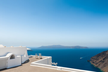 White architecture on Santorini island, Greece. Two chairs on the terrace with sea view. Famous travel destination