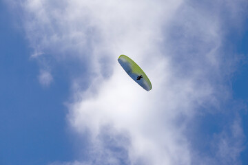 Silhouette from paraglider in the air over the cloudy sky.