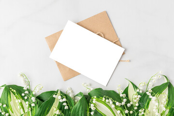 Blank greeting card with lily of the valley flowers on white background. Floral composition. Wedding invitation. mock up
