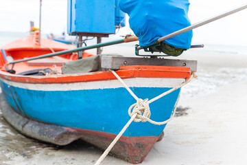 bow of a fishing boat blue and red closeup stands in the sand, soft focus