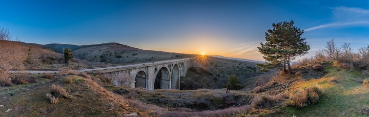 sunrise over the bridge with a blue sky in a panoramic photo