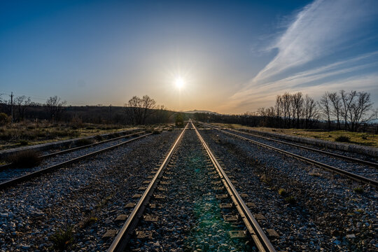 railway in the countryside with the sun and the blue sky