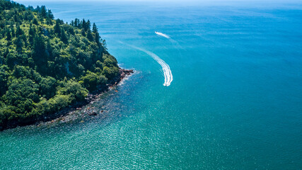 Boats running along a beautiful coastline. Coromandel, New Zealand.