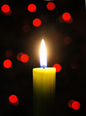 Candle Burning in the Dark with red boke in background