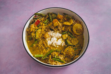 vegan yellow curry with mixed vegetables tofu and vermicelli noodles, healthy plant-based food